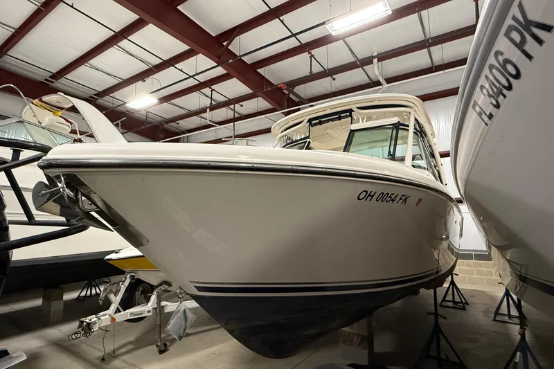 Slide: The Image of 2014 Pursuit DC 265 Dual Console boat in indoor showroom, side view. - 3