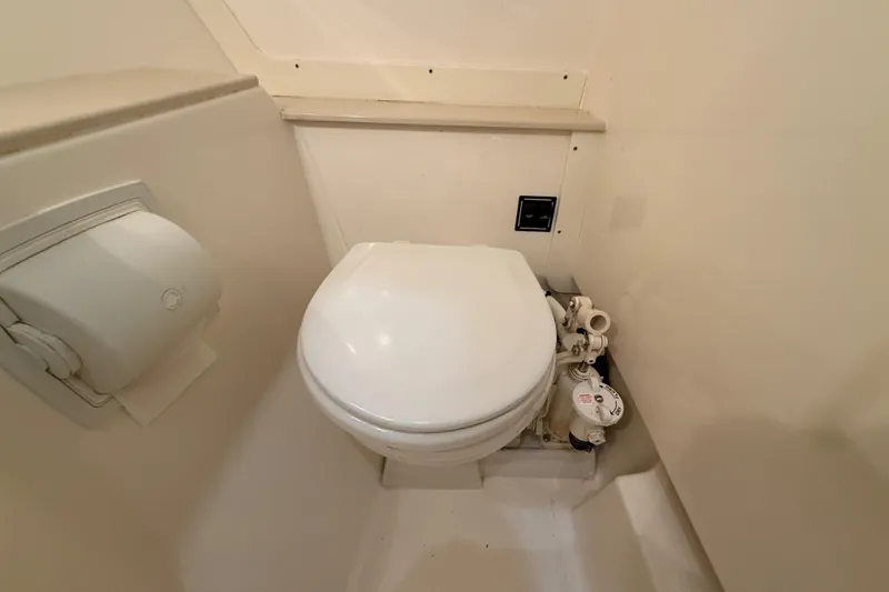 Slide: The Image of 2014 Pursuit DC 265 Dual Console boat bathroom with compact toilet setup. - 40