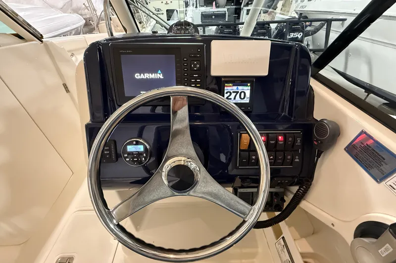 Slide: The Image of 2014 Pursuit DC 265 Dual Console boat dashboard with Garmin navigation system and steering wheel. - 43