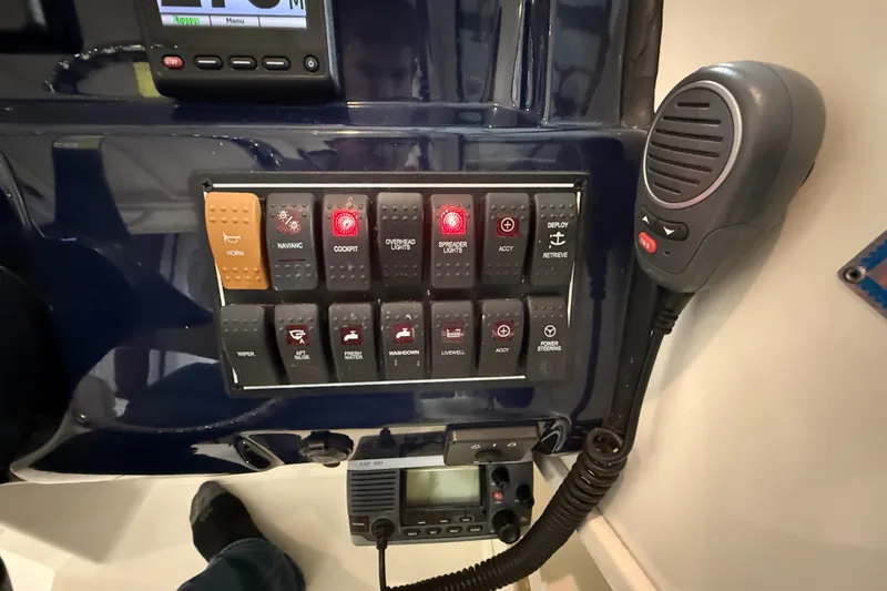 Slide: The Image of Control panel of a 2014 Pursuit DC 265 Dual Console boat with switches and microphone. - 44