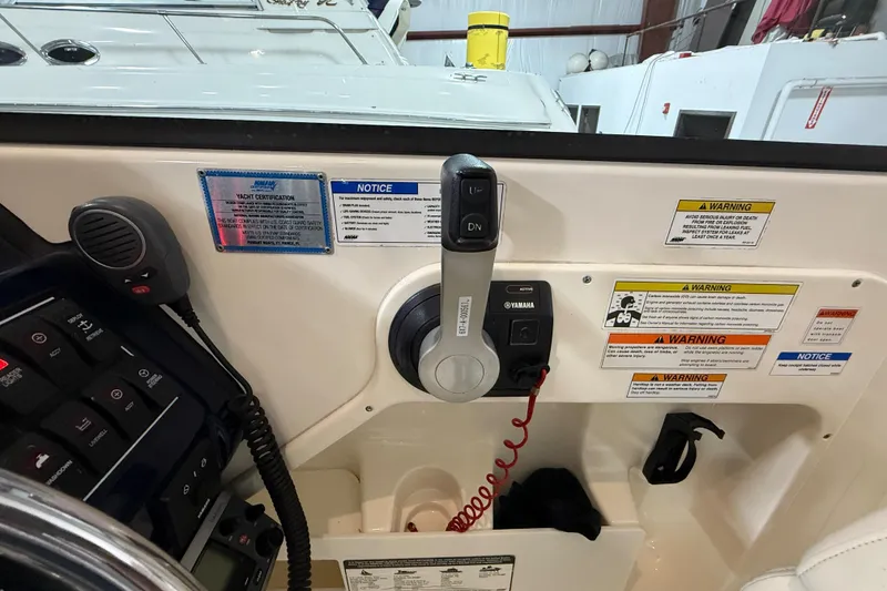 Slide: The Image of 2014 Pursuit DC 265 Dual Console boat controls with Yamaha throttle and safety warnings. - 49