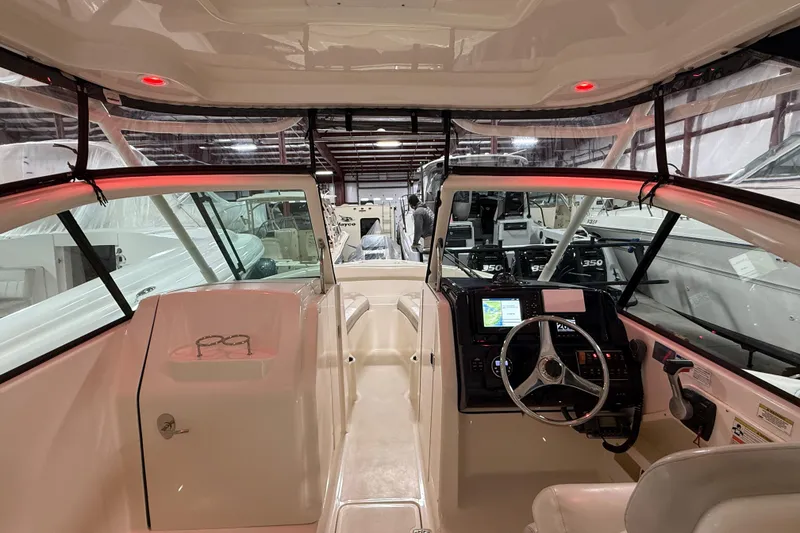 Slide: The Image of 2014 Pursuit DC 265 Dual Console boat interior with steering wheel and navigation system. - 50