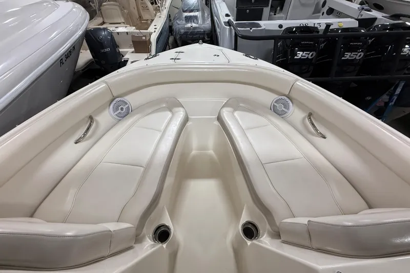 Slide: The Image of 2014 Pursuit DC 265 Dual Console boat interior with white seating and speakers. - 54