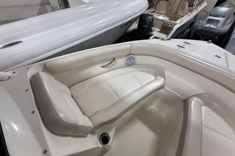 Slide: The Image of 2014 Pursuit DC 265 Dual Console boat interior with white seating and speaker. - 55