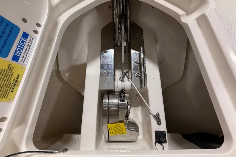 Slide: The Image of 2014 Pursuit DC 265 Dual Console anchor compartment with winch and safety notices. - 58