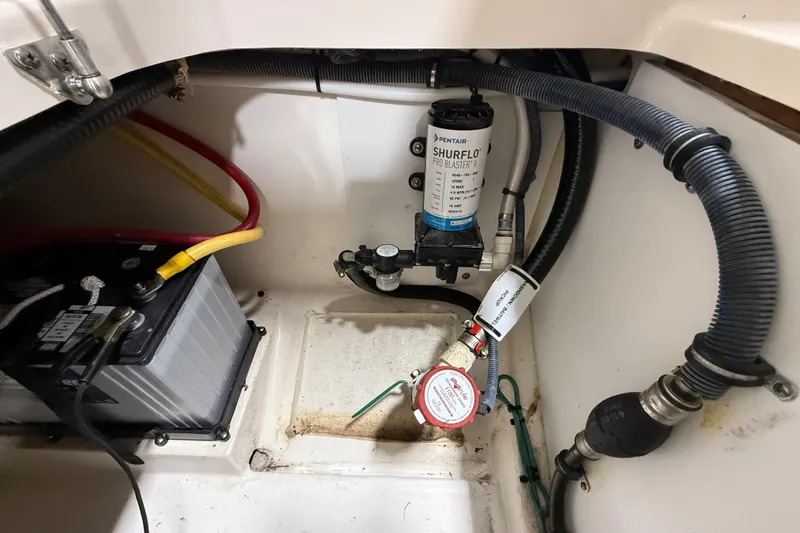 Slide: The Image of 2014 Pursuit DC 265 Dual Console boat interior with battery and Shurflo pump system. - 62