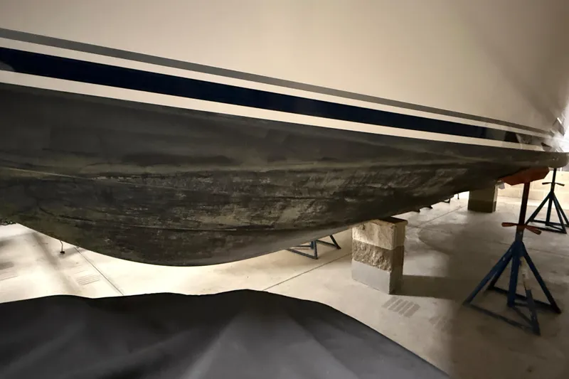 Slide: The Image of 2014 Pursuit DC 265 Dual Console boat hull on stands in storage. - 64