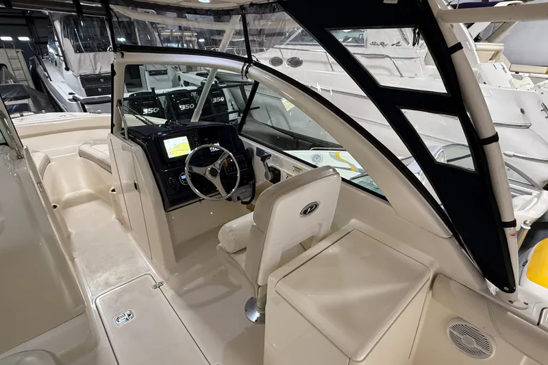Slide: The Image of 2014 Pursuit DC 265 Dual Console with Yamaha 350 V8 engine in a boat storage facility. - 9