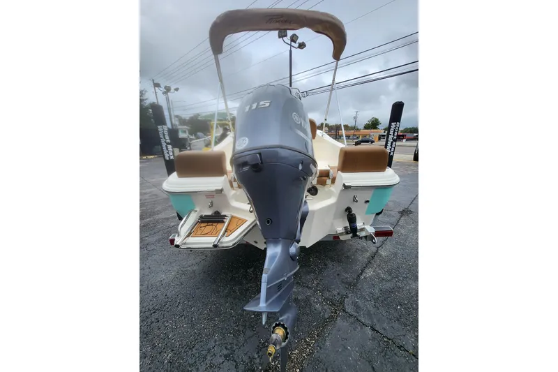 Slide: The Image of 2026 Pioneer 180 Islander boat with outboard motor and canopy, rear view. - 2