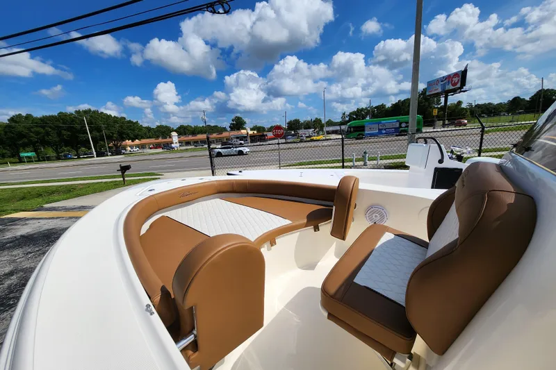 Slide: The Image of 2026 Pioneer 180 Islander boat interior with brown and white seating under a blue sky. - 9