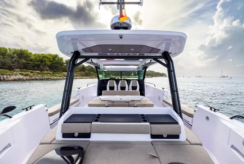 Slide: The Image of 2025 Axopar 45 Cross Top boat interior with seating, on a scenic water backdrop. - 7