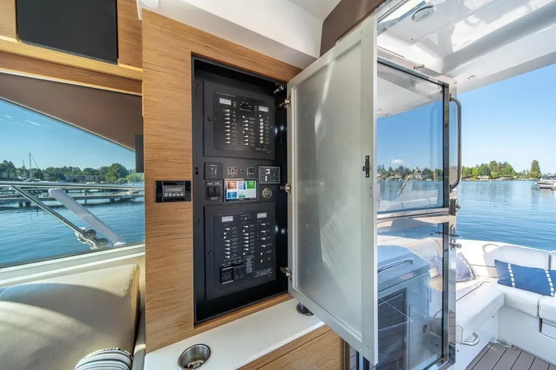 Slide: The Image of 2017 Cruisers Yachts 45 Cantius electrical panel with open door, overlooking serene marina. - 17