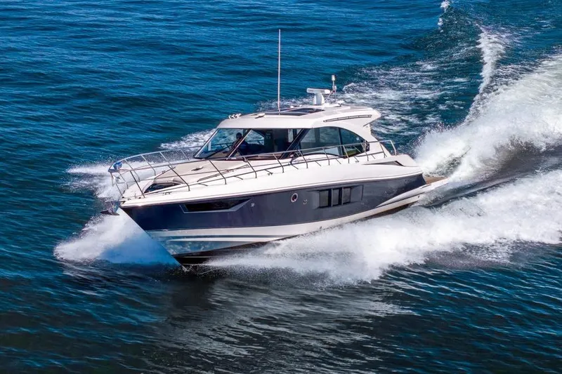 Slide: The Image of 2017 Cruisers Yachts 45 Cantius cruising on open water, creating waves. - 2