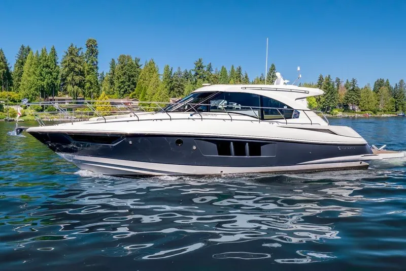 Slide: The Image of 2017 Cruisers Yachts 45 Cantius on a serene lake with lush green trees. - 7
