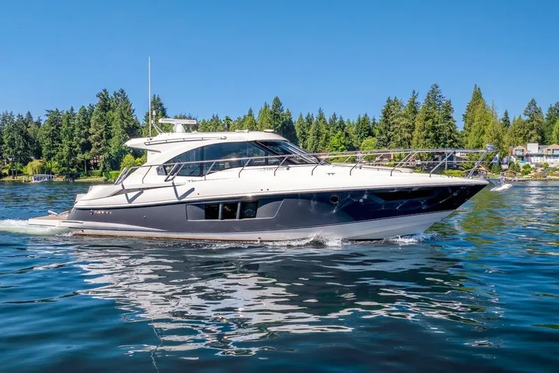 Slide: The Image of 2017 Cruisers Yachts 45 Cantius cruising on a serene lake with forested shoreline. - 8