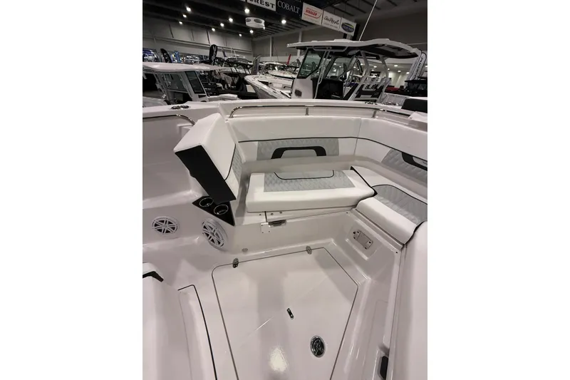 Slide: The Image of 2026 Blackfin 302 CC boat interior with seating and speakers in a showroom. - 16