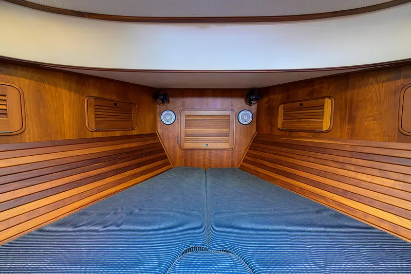 Slide: The Image of Interior cabin of 2006 Hinckley Talaria 40 with wood paneling and striped bedding. - 18