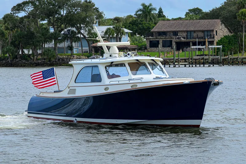 Slide: The Image of 2006 Hinckley Talaria 40 yacht cruising on a scenic waterway with American flag. - 3