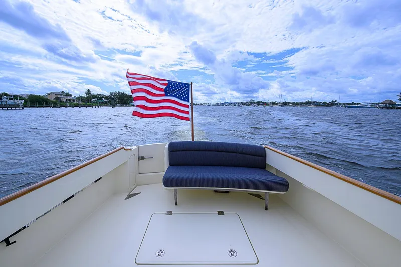 Slide: The Image of Hinckley Talaria 40 boat, 2006 model, with American flag on open water under cloudy sky. - 5