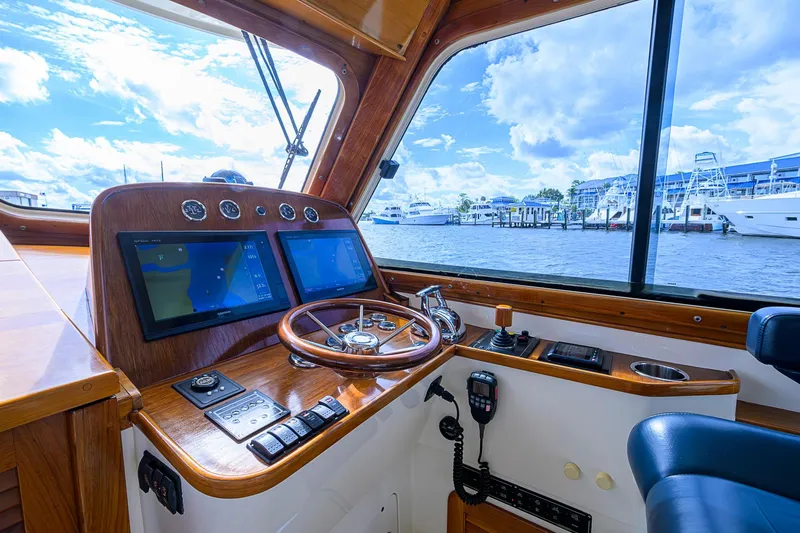 Slide: The Image of Helm of 2006 Hinckley Talaria 40 yacht with navigation screens and wooden steering wheel. - 12