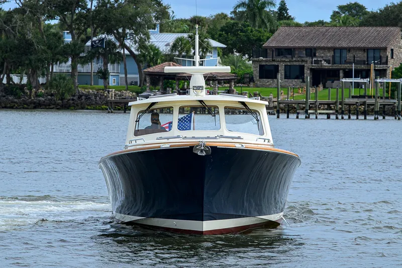 Slide: The Image of 2006 Hinckley Talaria 40 yacht cruising on a scenic waterfront. - 2
