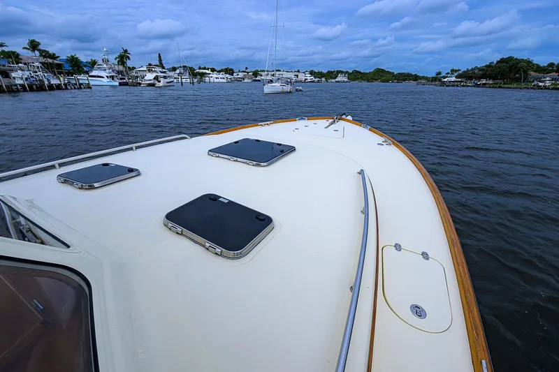 Slide: The Image of 2006 Hinckley Talaria 40 yacht deck on calm waters, with scenic marina view. - 22