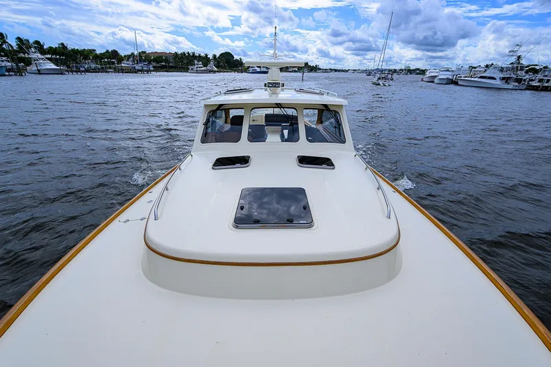 Slide: The Image of 2006 Hinckley Talaria 40 yacht cruising on a scenic waterway under a cloudy sky. - 24