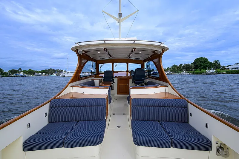 Slide: The Image of 2006 Hinckley Talaria 40 boat interior with blue seating, cruising on a calm river. - 6