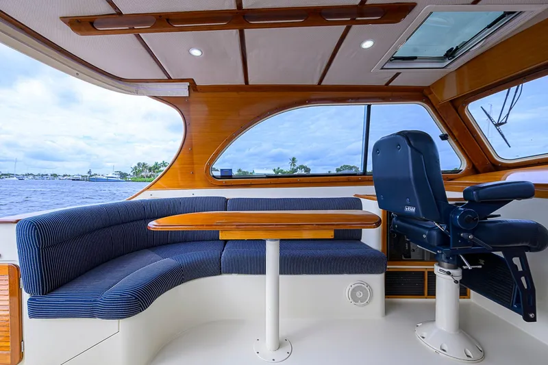 Slide: The Image of Interior of 2006 Hinckley Talaria 40 yacht with blue seating and wooden table. - 8