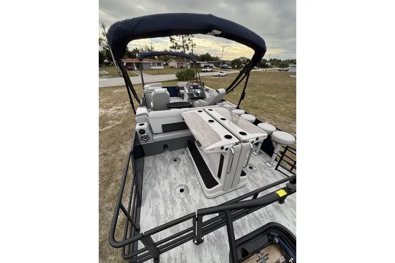 Slide: The Image of 2026 Starcraft SLS 3DL DH BAR boat with seating and canopy, parked outdoors. - 7