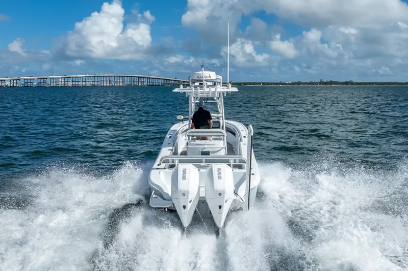 Slide: The Image of 2021 Yellowfin 26 Hybrid boat cruising on open water with bridge in background. - 17