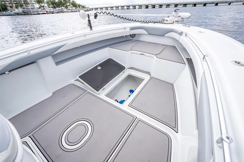 Slide: The Image of 2021 Yellowfin 26 Hybrid boat interior with storage compartments, docked by the water. - 24
