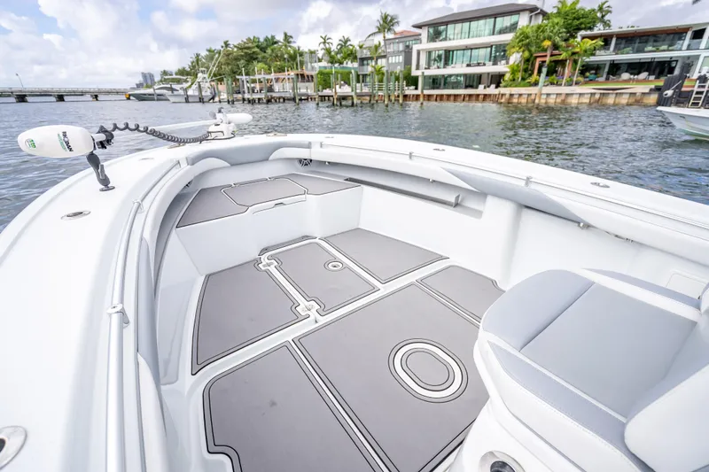Slide: The Image of 2021 Yellowfin 26 Hybrid boat interior with sleek design, docked near waterfront homes. - 25