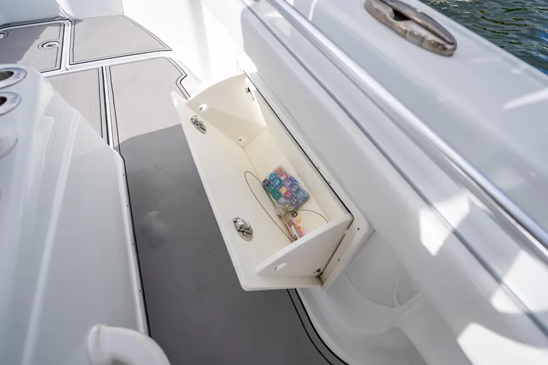 Slide: The Image of 2021 Yellowfin 26 Hybrid boat storage compartment with open hatch and visible contents. - 26