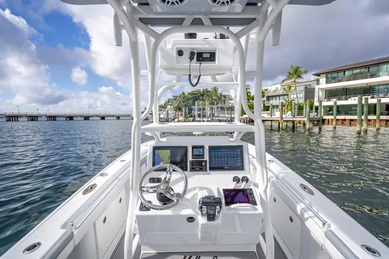 Slide: The Image of 2021 Yellowfin 26 Hybrid boat interior with modern dashboard and steering, dockside view. - 28