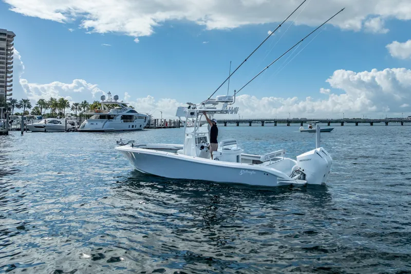 Slide: The Image of 2021 Yellowfin 26 Hybrid boat on water near marina, clear sky background. - 4