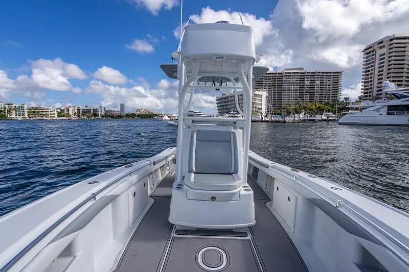 Slide: The Image of 2021 Yellowfin 26 Hybrid boat on water with city skyline and marina backdrop. - 47