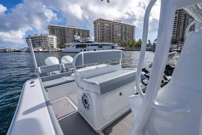 Slide: The Image of 2021 Yellowfin 26 Hybrid boat docked near waterfront buildings under cloudy sky. - 48
