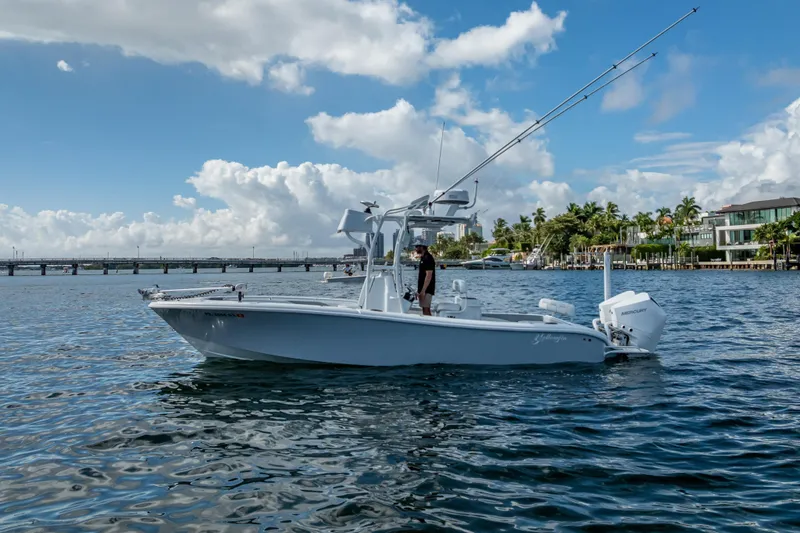 Slide: The Image of 2021 Yellowfin 26 Hybrid boat on water, clear sky, coastal background. - 5