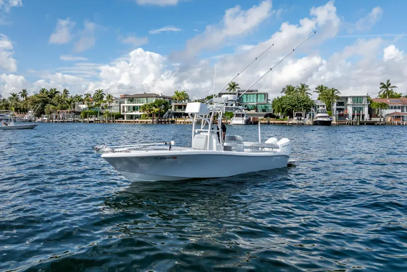 Slide: The Image of 2021 Yellowfin 26 Hybrid boat on water, with waterfront homes in the background. - 6