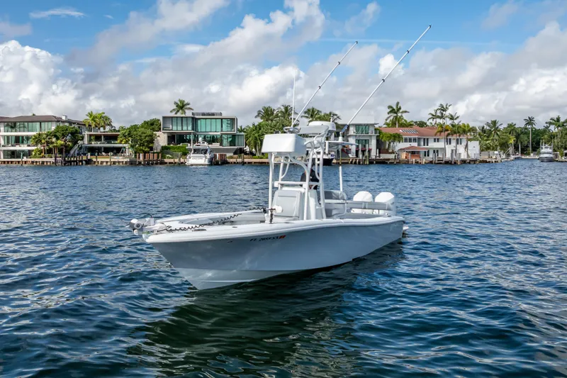 Slide: The Image of 2021 Yellowfin 26 Hybrid boat on water near luxury waterfront homes. - 7