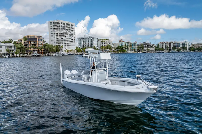 Slide: The Image of 2021 Yellowfin 26 Hybrid boat on water with cityscape background. - 9