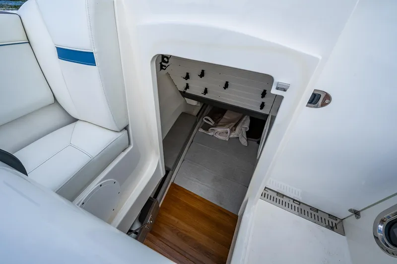 Slide: The Image of Interior storage compartment of 2021 Tiara Yachts 38 LX, featuring white seating and wooden flooring. - 11