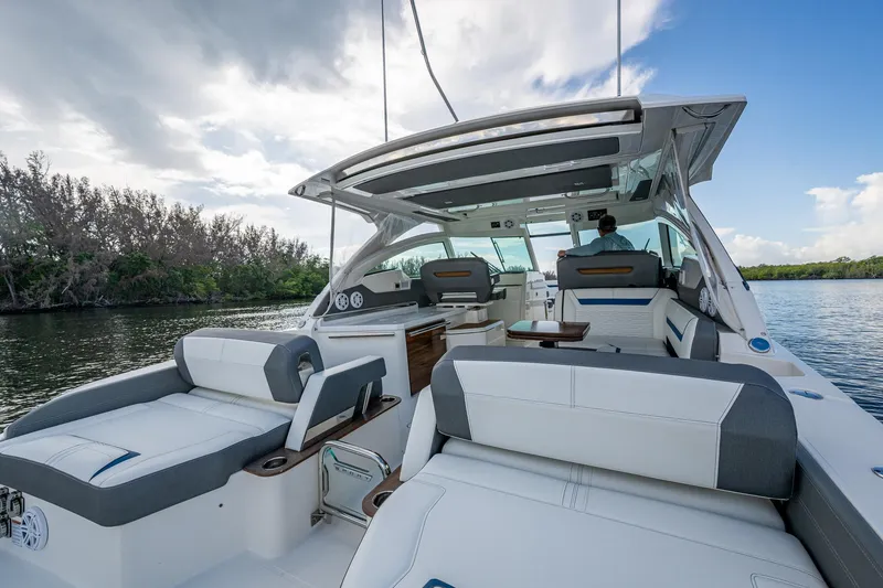 Slide: The Image of 2021 Tiara Yachts 38 LX luxury boat interior with seating, on a calm waterway. - 14