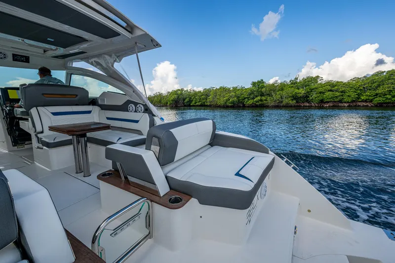 Slide: The Image of 2021 Tiara Yachts 38 LX cruising on a serene waterway with lush greenery. - 15