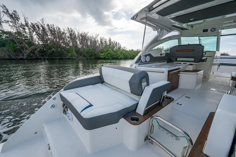 Slide: The Image of 2021 Tiara Yachts 38 LX luxury boat interior with seating, on a calm river. - 16