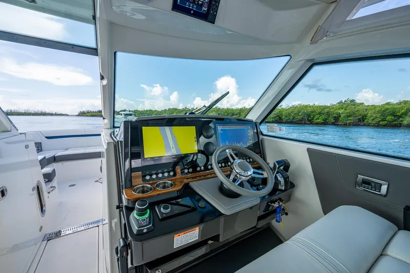 Slide: The Image of Interior view of 2021 Tiara Yachts 38 LX helm with navigation screens and steering wheel. - 18