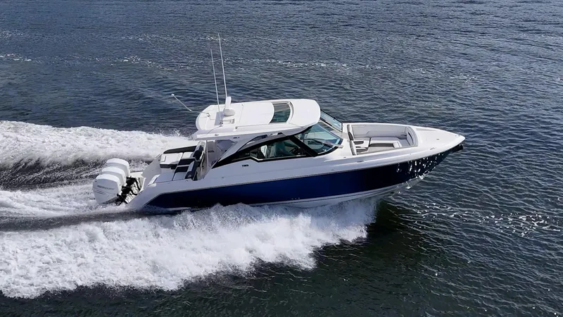 Slide: The Image of 2021 Tiara Yachts 38 LX cruising on open water, showcasing sleek design and powerful engines. - 2