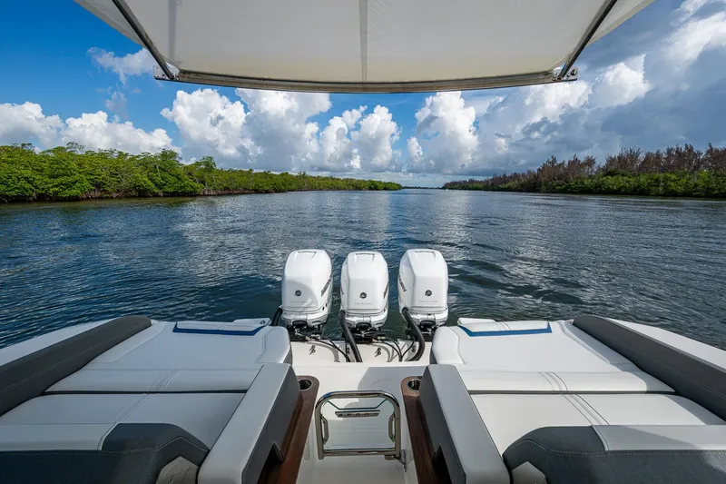 Slide: The Image of 2021 Tiara Yachts 38 LX with triple engines cruising on a scenic waterway. - 37