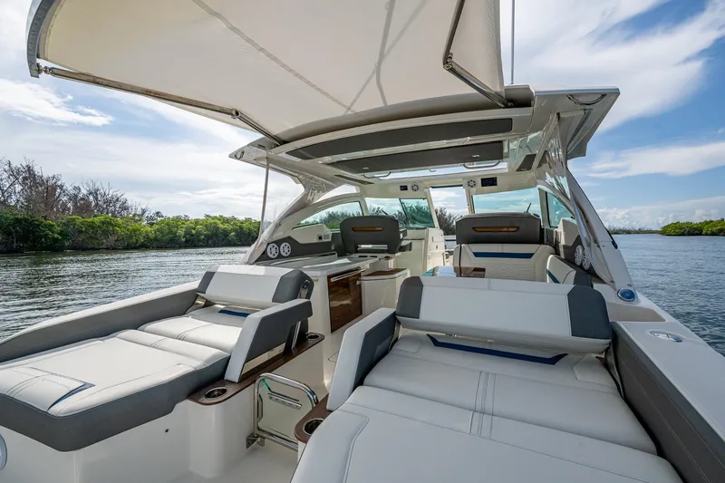 Slide: The Image of 2021 Tiara Yachts 38 LX luxury boat interior with seating, canopy, and scenic water view. - 38